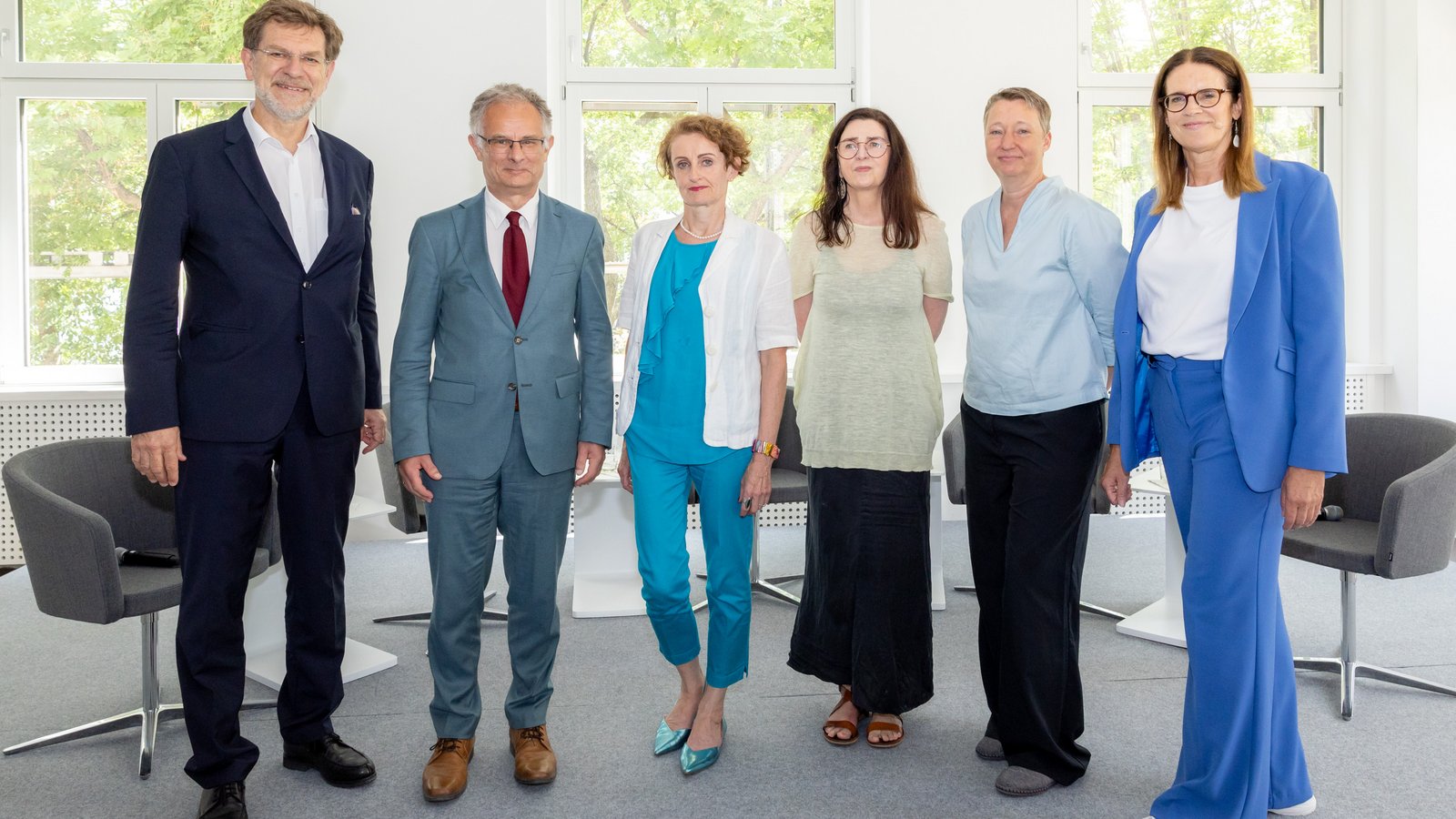 Das Bild zeigt sechs Personen stehend vor einem Fenster. v.l.: Mag. Andreas Zakostelsky, Obmann des Fachverbandes der Pensions- und Vorsorgekassen WKÖ, Bundesminister für Finanzen Dr. Markus Marterbauer, Vorsitzende der Alterssicherungskommission Mag.a Christine Mayrhuber, Bundesgeschäftsführerin des ÖGB Dr. Helene Schuberth, AK Abteilungsleiterin Sozialpolitik Maga. Sybille Pirklbauer, Moderatorin Hanna Kordik.