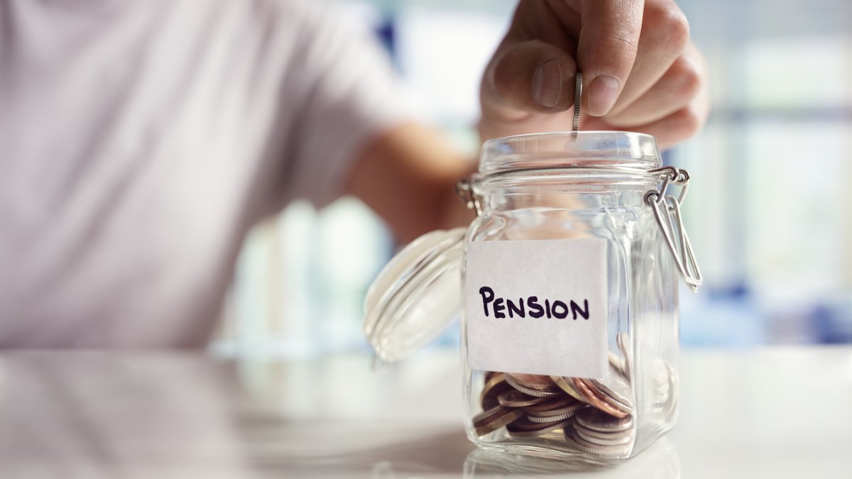 Das Bild zeigt, die ein Mann Münzen in ein Glas mit der Aufschrift Pension wirft