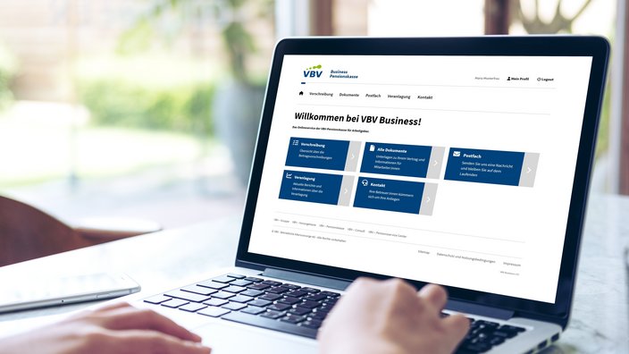 Am Tisch steht ein Laptop. Darauf zu sehen ist das Arbeitgeberportal VBV Business Pensionskasse, das Portal für Firmenkunden der VBV-Pensionskasse.