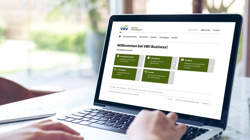 Am Tisch steht ein Laptop. Darauf zu sehen ist das Arbeitgeberportal VBV Business Vorsorgekasse, das Portal für Firmenkunden der VBV-Vorsorgekasse.