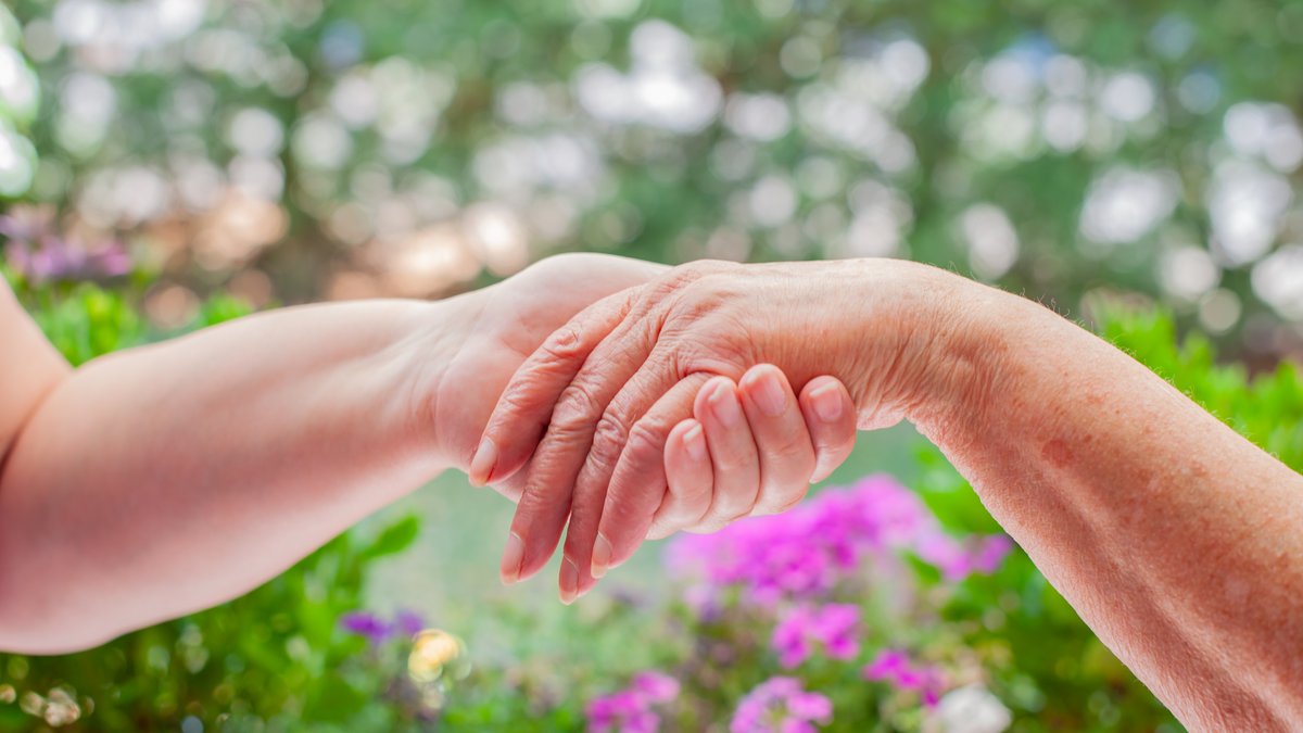 Eine junge Hand hält eine ältere Hand
