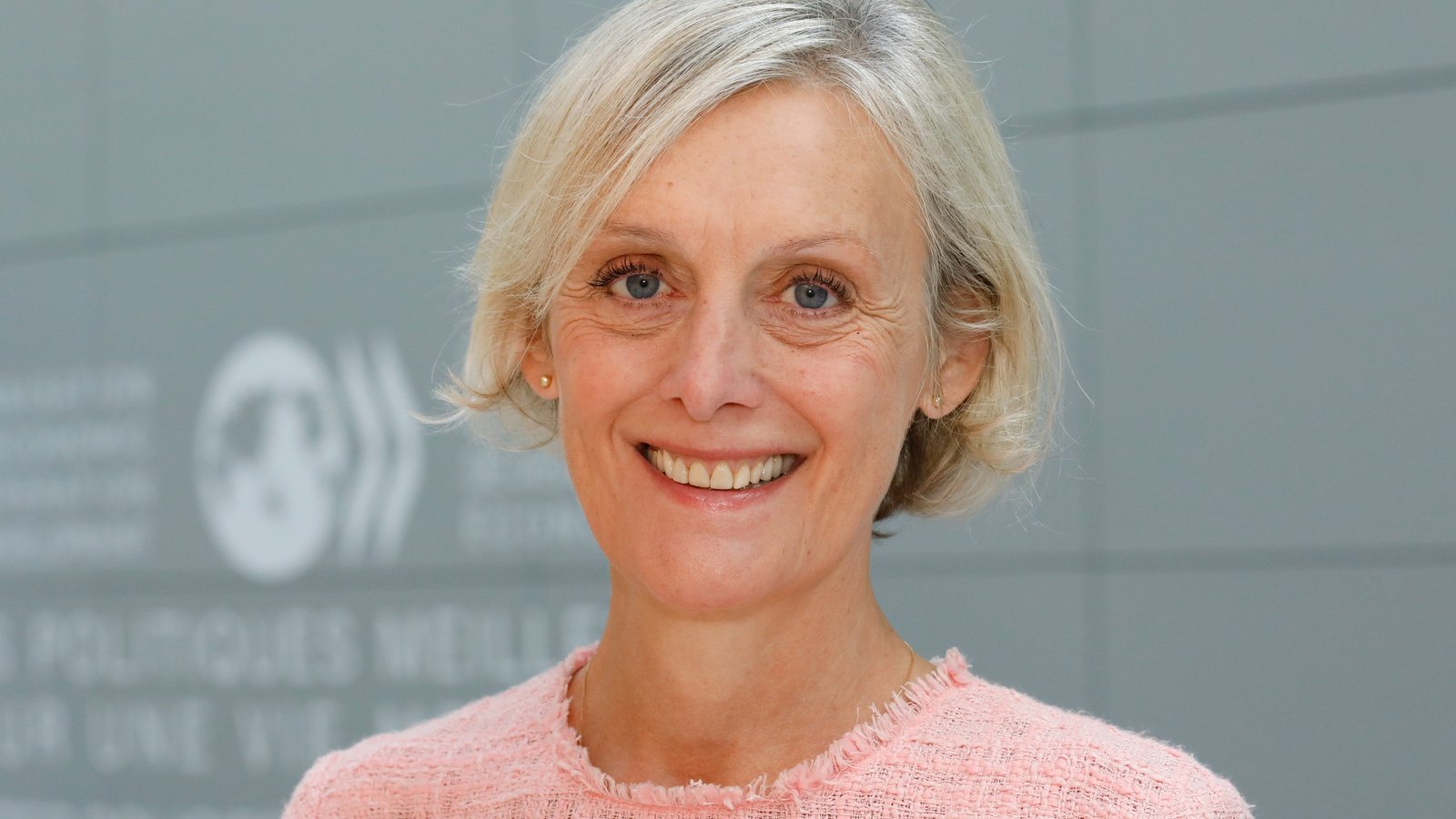 Ein Portraitfoto von Monika Queisser vor dem OECD-Gebäude