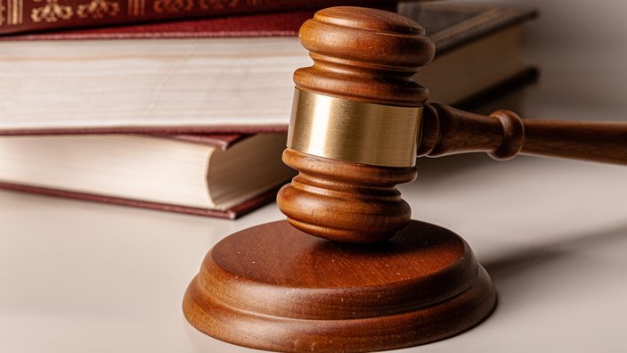 Foto von einem Richterstab und juristischen Büchern auf einem Tisch