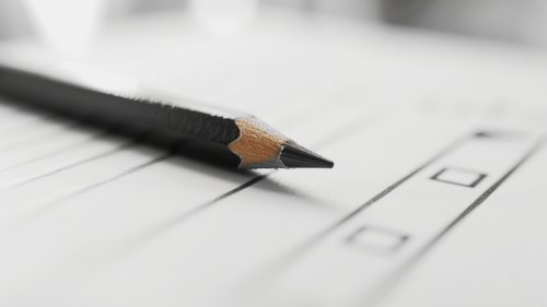 Das Bild zeigt einen Bleistift, der auf einem Blatt Papier liegt.