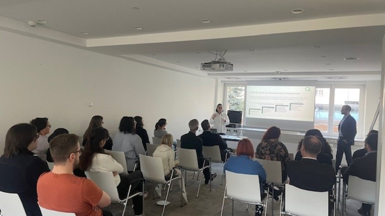 Mitarbeiter:innen hören gespannt dem Vortrag der Green Finance Alliance