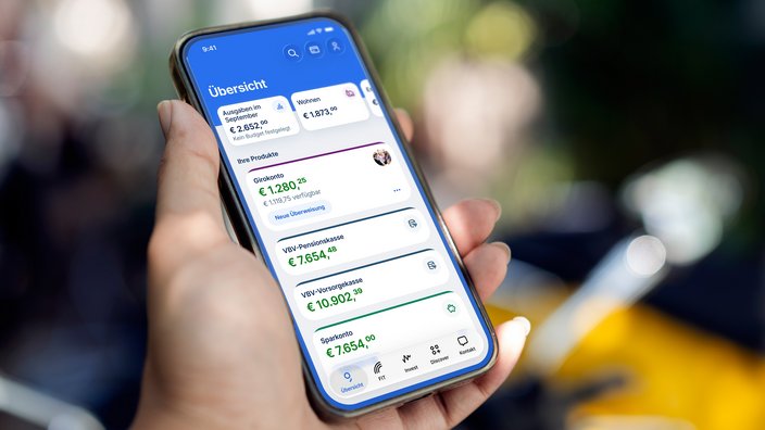 Eine Frau hält ein Mobiltelefon, darauf ist das Internetbanking George der Erste Bank und Sparkassen zusehen.